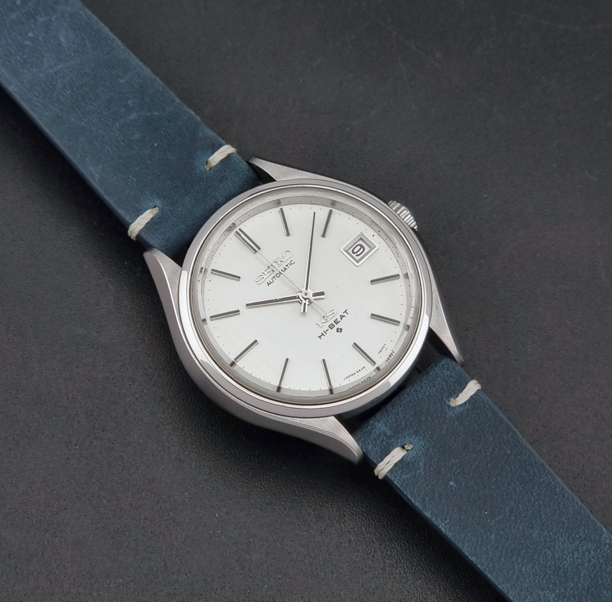 Vintage King Seiko 5625-7121 watch with blue strap on a dark gray background close up dial view