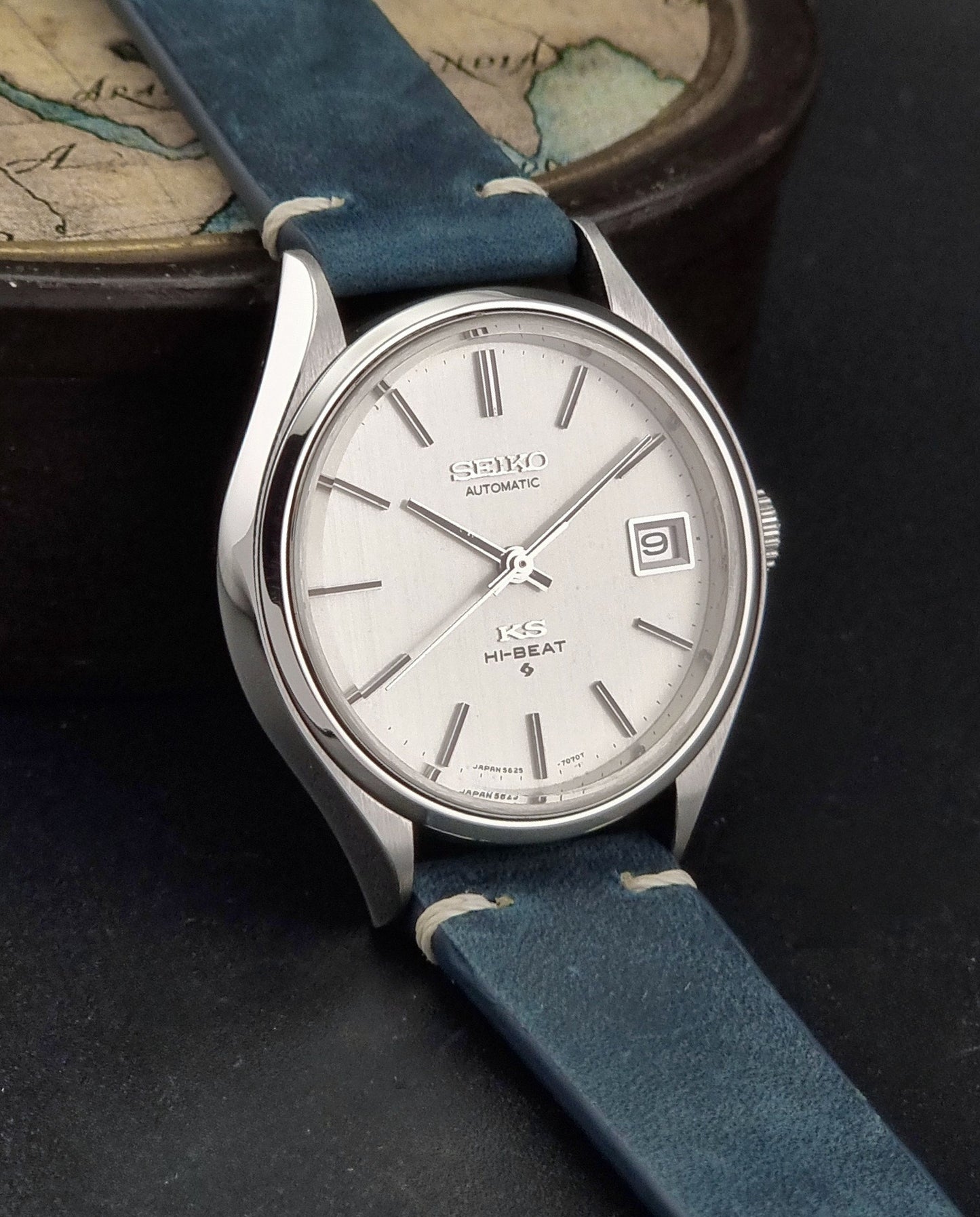 Vintage King Seiko 5625-7121 watch with blue strap on a dark gray background side view