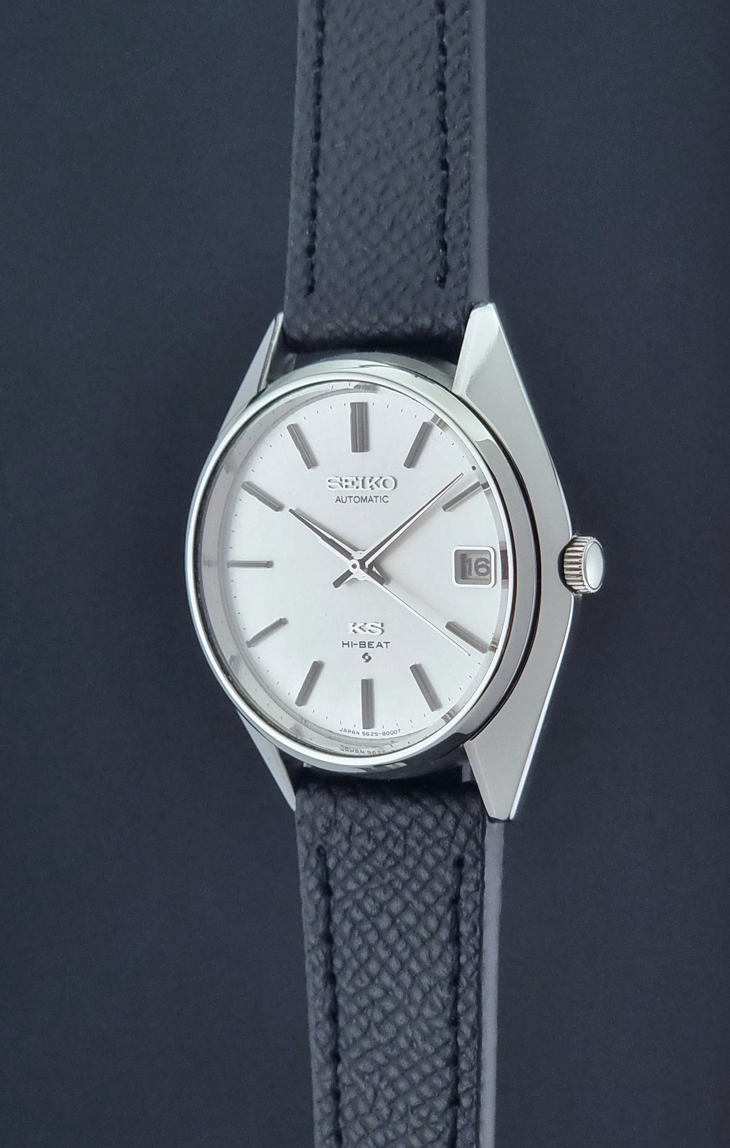 Vintage King Seiko Wristwatch 5625-8000 with a black leather strap on a dark background crown profile view