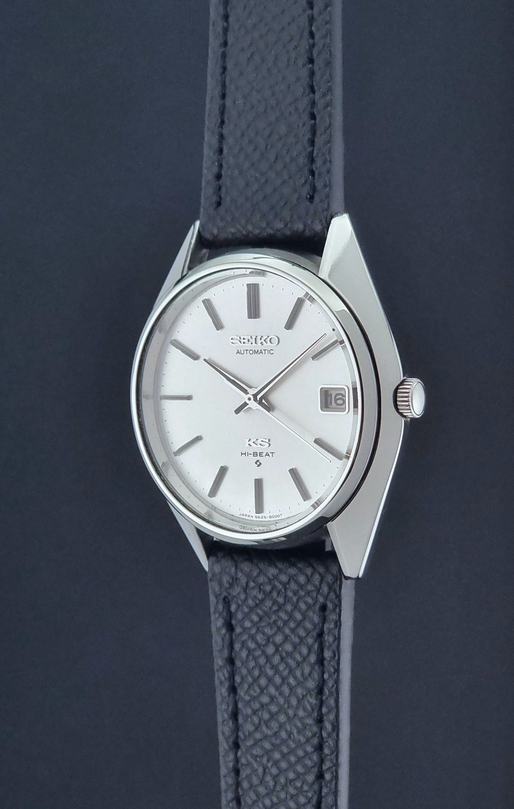 Vintage King Seiko Wristwatch 5625-8000 with a black leather strap on a dark background crown profile view