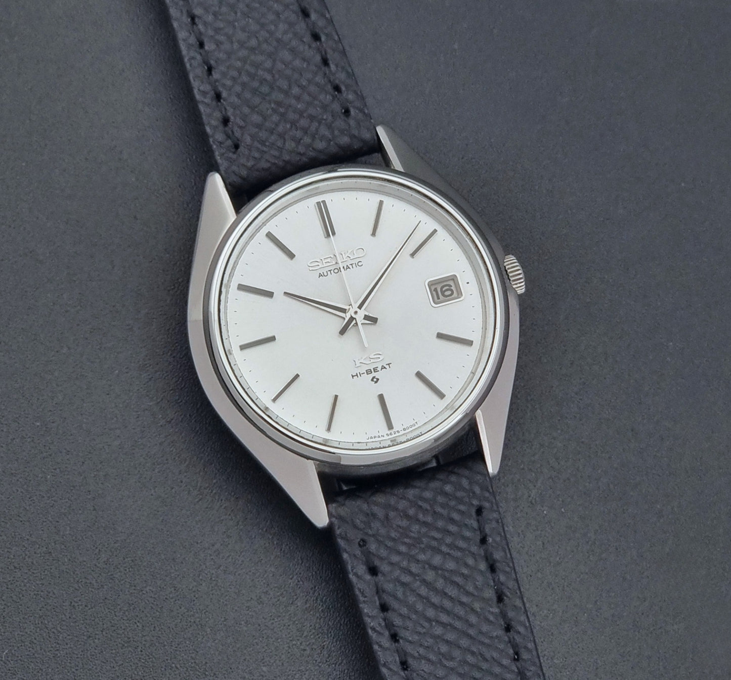Vintage King Seiko Wristwatch 5625-8000 with a black leather strap on a dark background front view