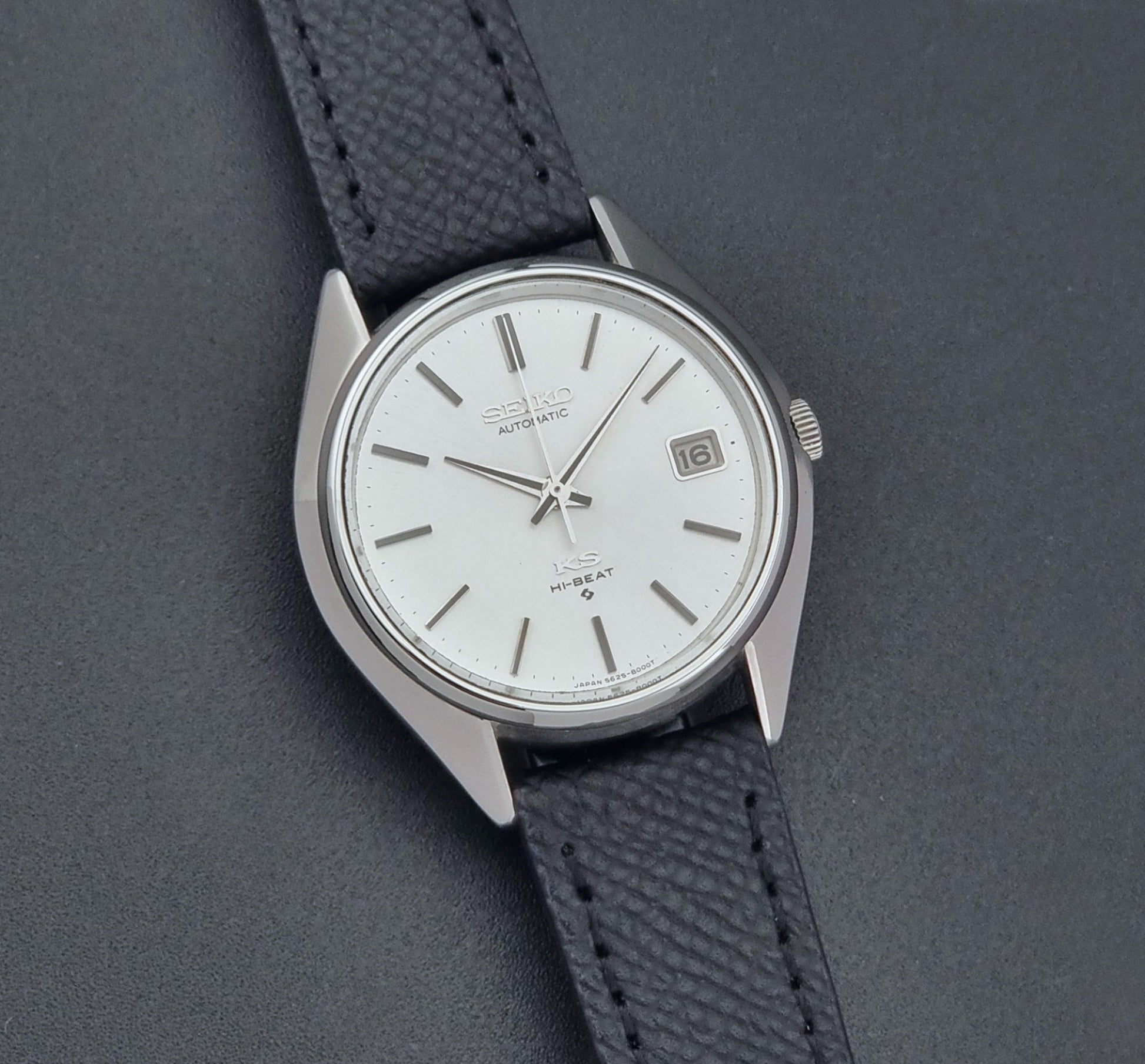 Vintage King Seiko Wristwatch 5625-8000 with a black leather strap on a dark background front view