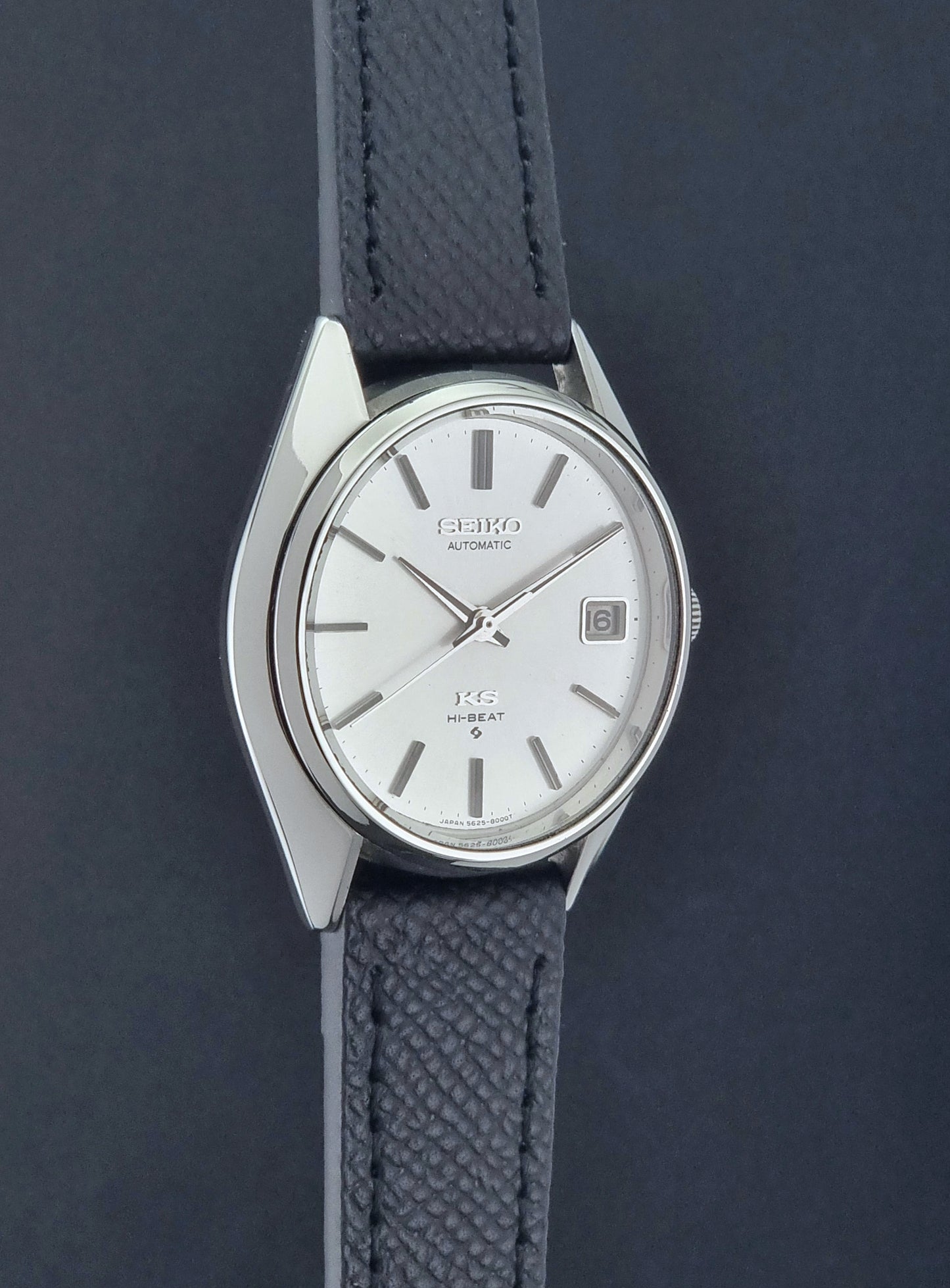 Vintage King Seiko Wristwatch 5625-8000 with a black leather strap on a dark background side profile view