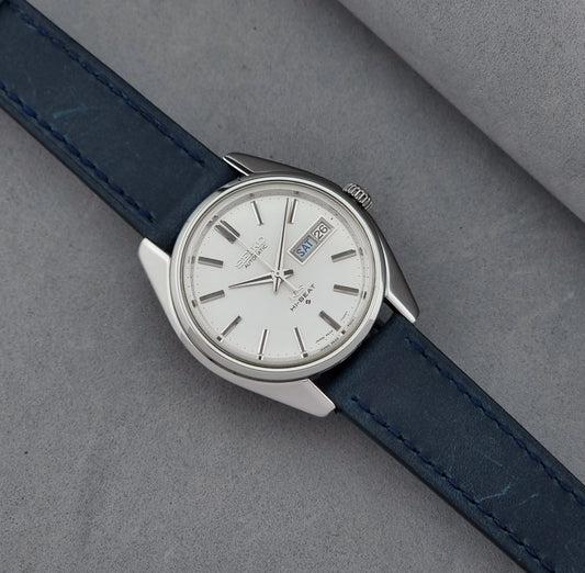 Vintage King Seiko Wristwatch 5626-7000 with blue strap and silver case on a gray background dial