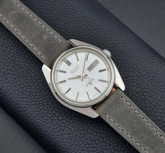 King Seiko 5626-7000 Wristwatch with gray leather strap and silver case on a dark textured background