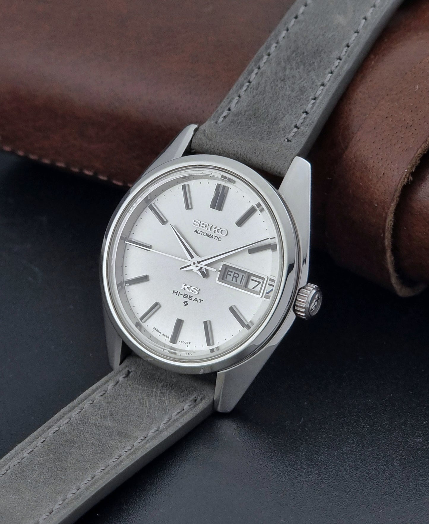 Vintage King Seiko wristwatch with gray leather strap on a dark background crown view