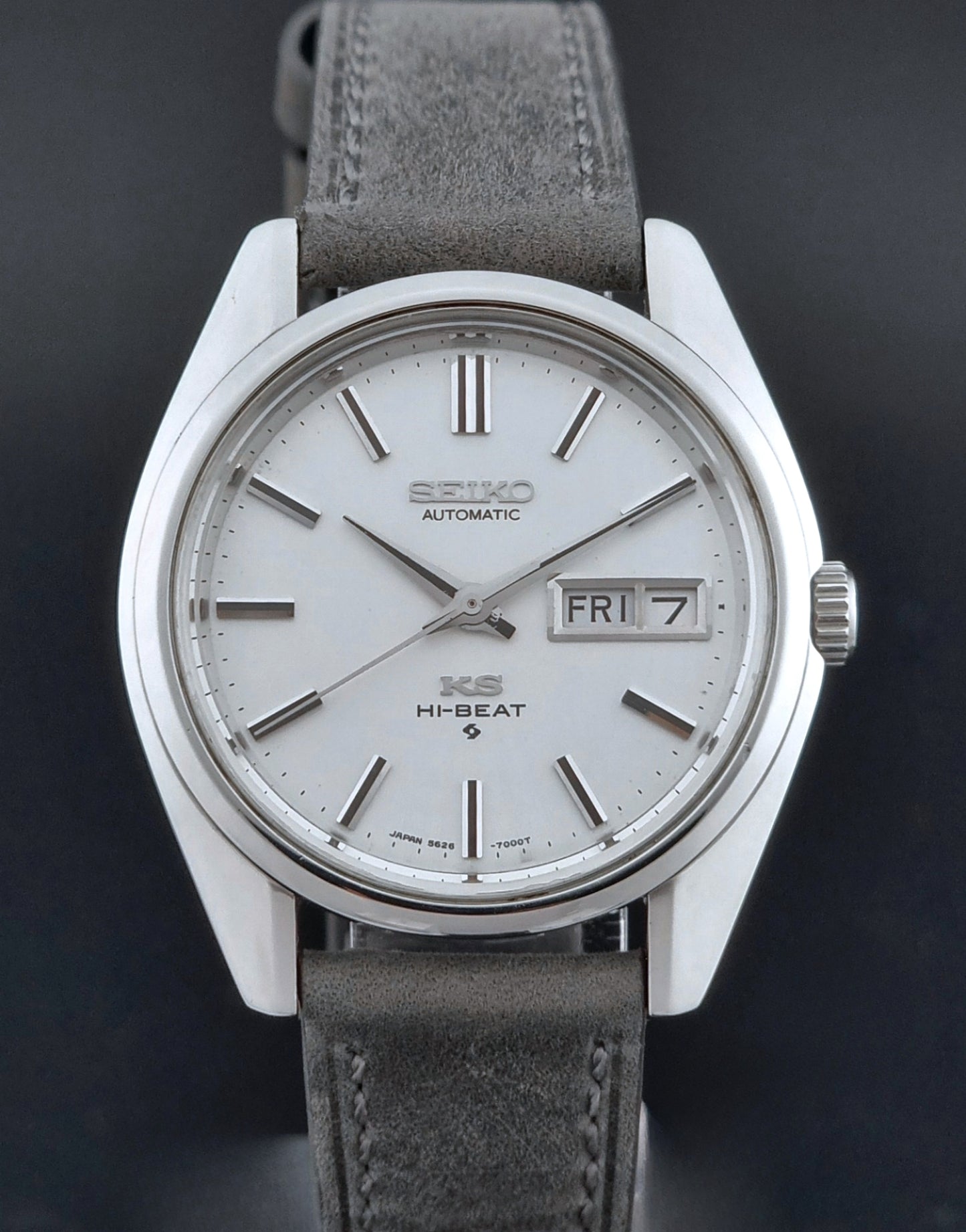 Vintage King Seiko wristwatch with gray leather strap on a dark background close up view