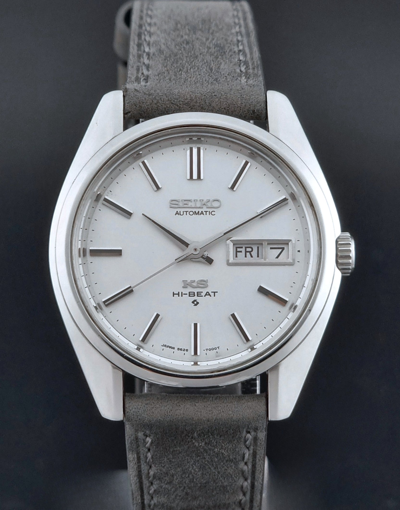 Vintage King Seiko wristwatch with gray leather strap on a dark background close up view