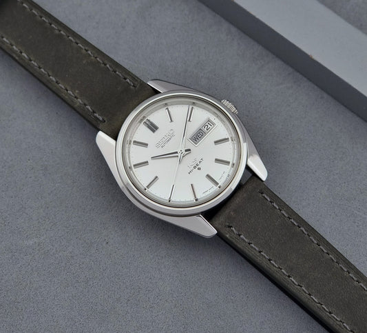 Vintage King Seiko Wristwatch 5626-7000  with grey leather strap on a grey surface dial
