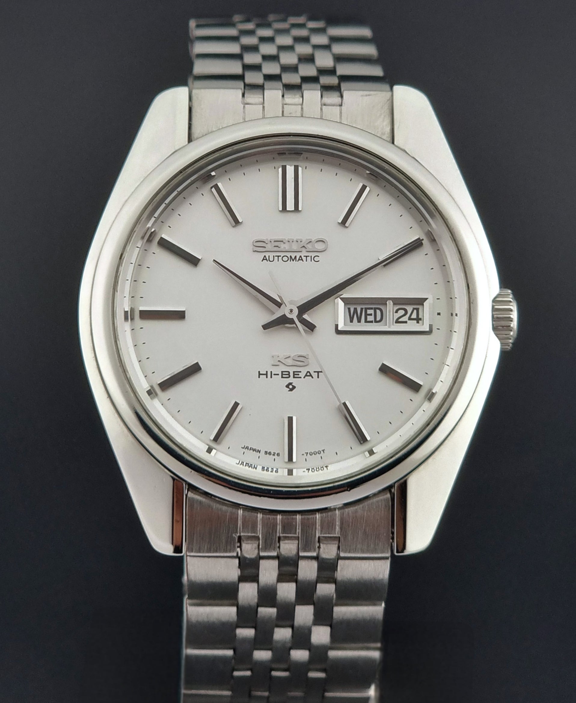 Silver Seiko watch with a white face on a dark background
