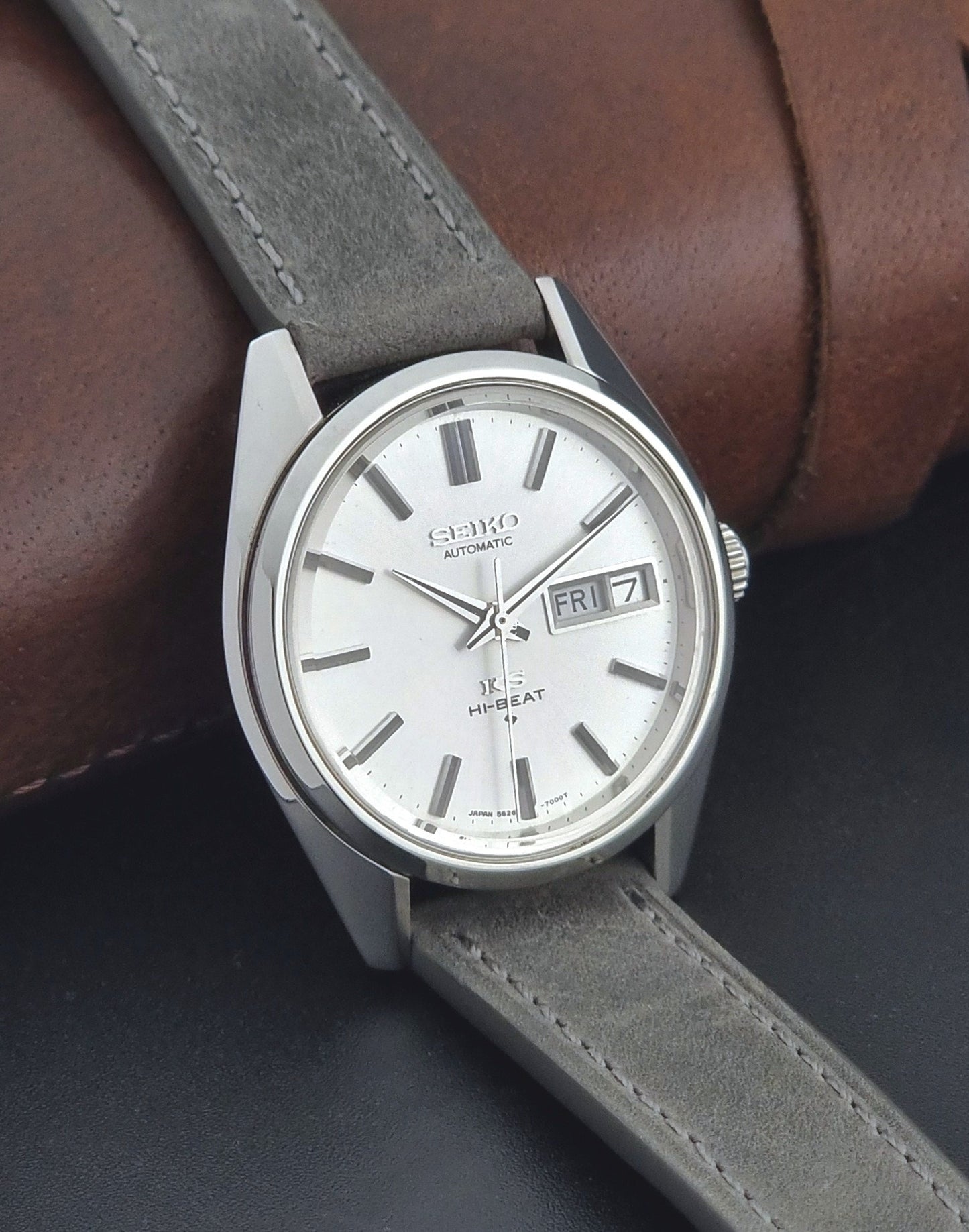 Vintage King Seiko wristwatch with gray leather strap on a dark background side view
