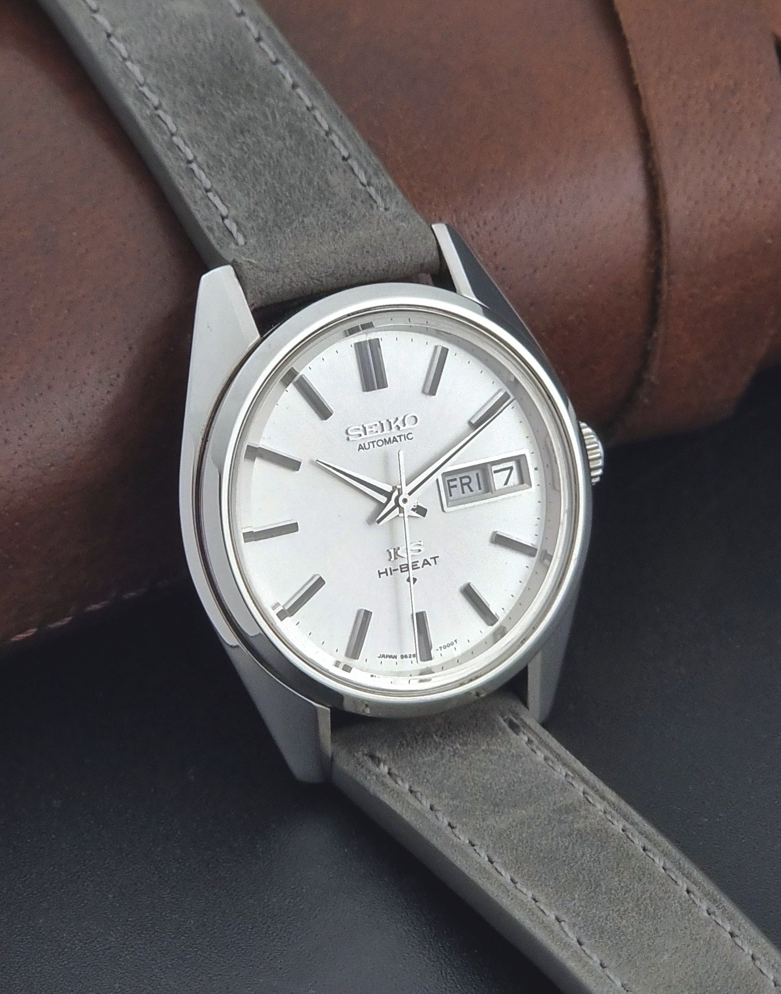 Vintage King Seiko wristwatch with gray leather strap on a dark background side view