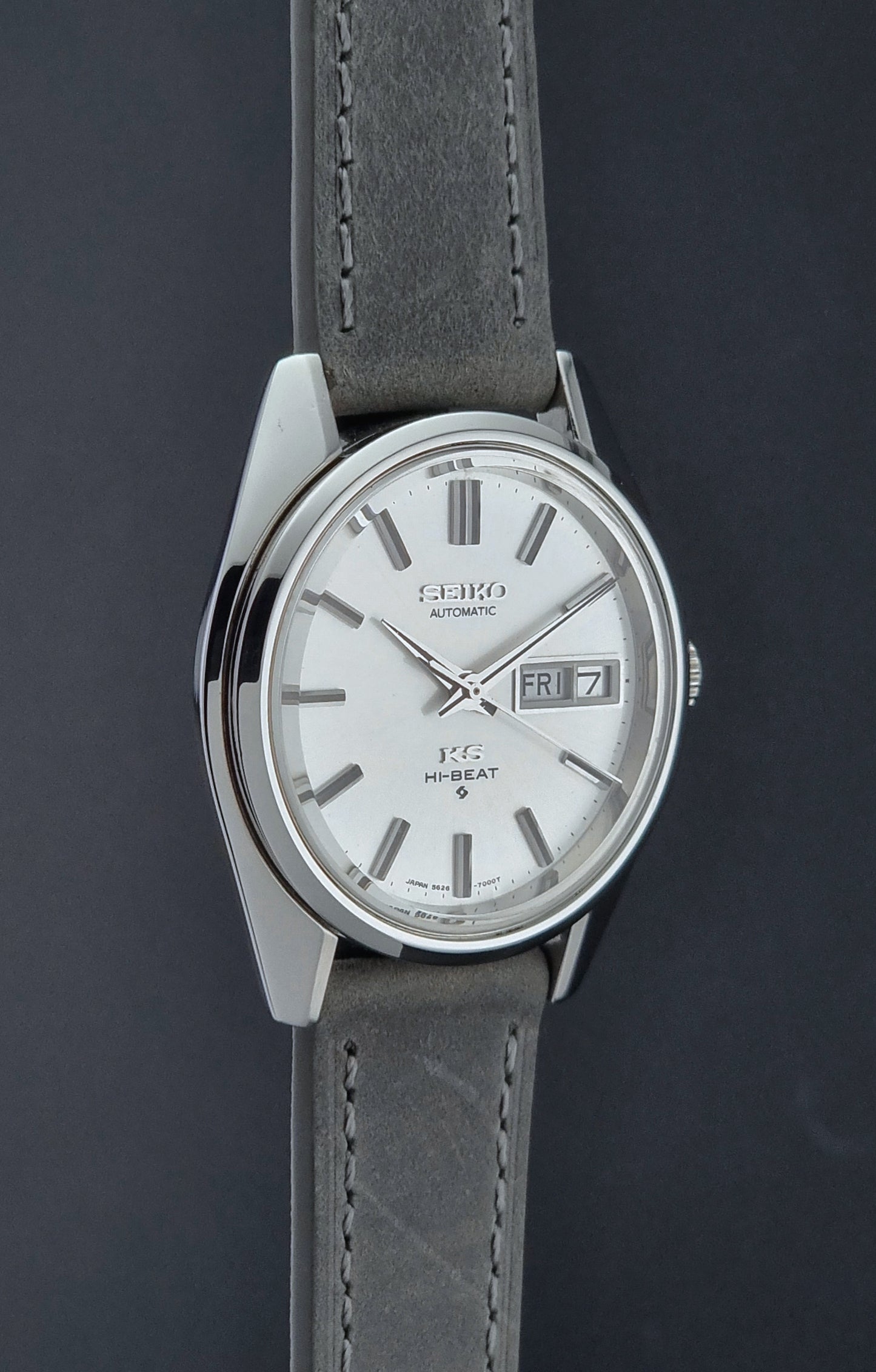 Vintage King Seiko wristwatch with gray leather strap on a dark background side profile