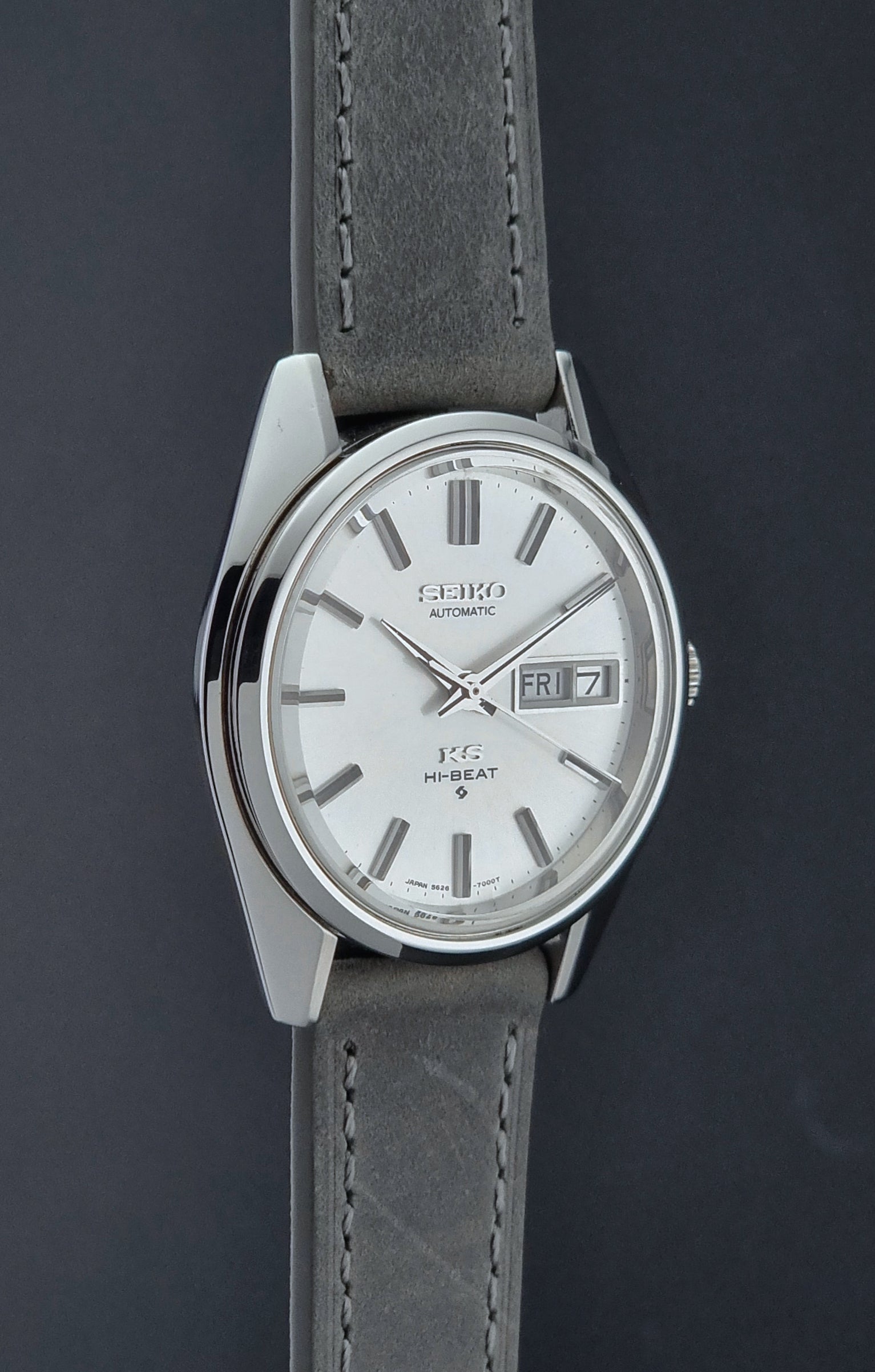 Vintage King Seiko wristwatch with gray leather strap on a dark background side profile
