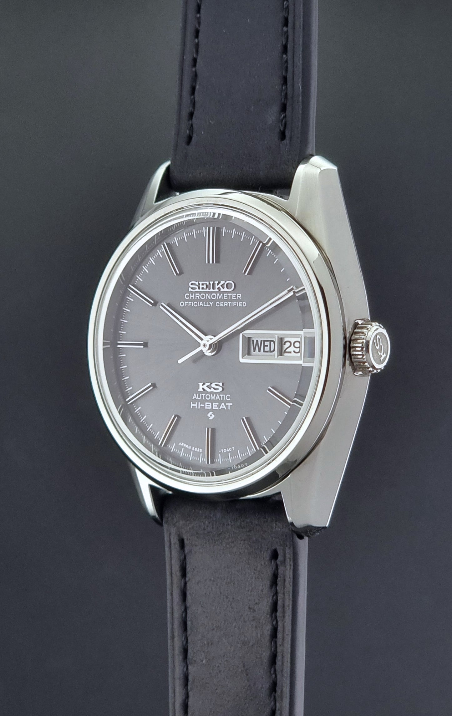 King Seiko watch 5626-7040 watch with black leather strap on a green and gray background crown profile view