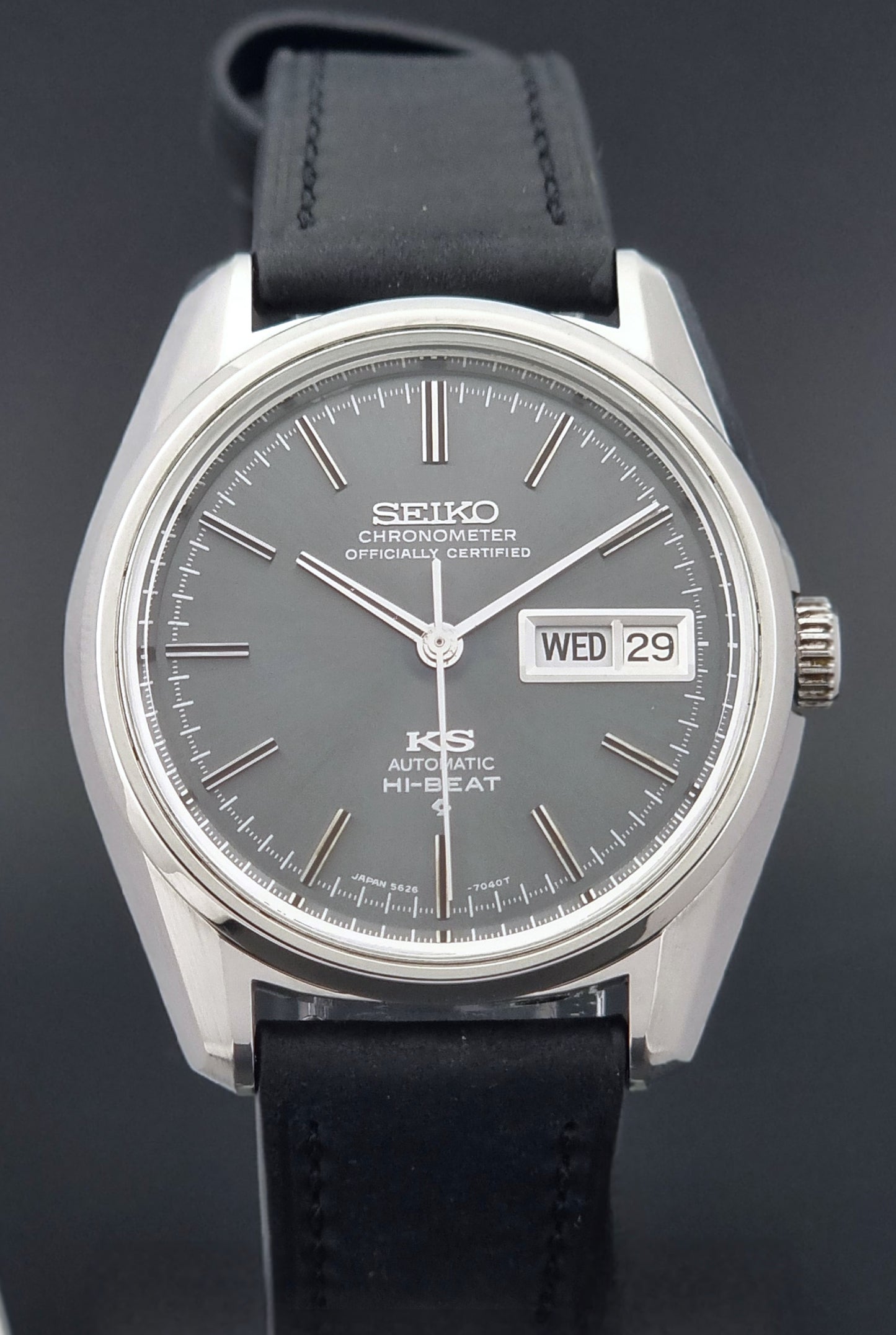 King Seiko watch 5626-7040 watch with black leather strap on a green and gray background front view