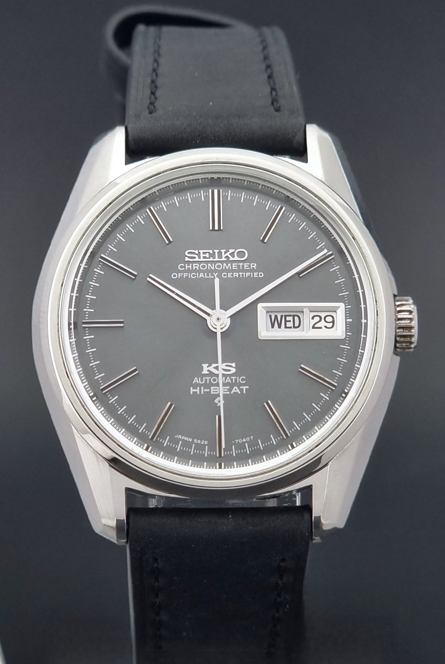 King Seiko watch 5626-7040 watch with black leather strap on a green and gray background front view