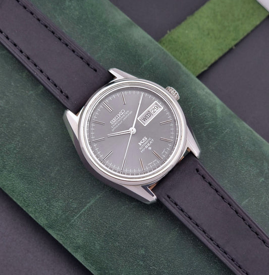 King Seiko watch 5626-7040 watch with black leather strap on a green and gray background