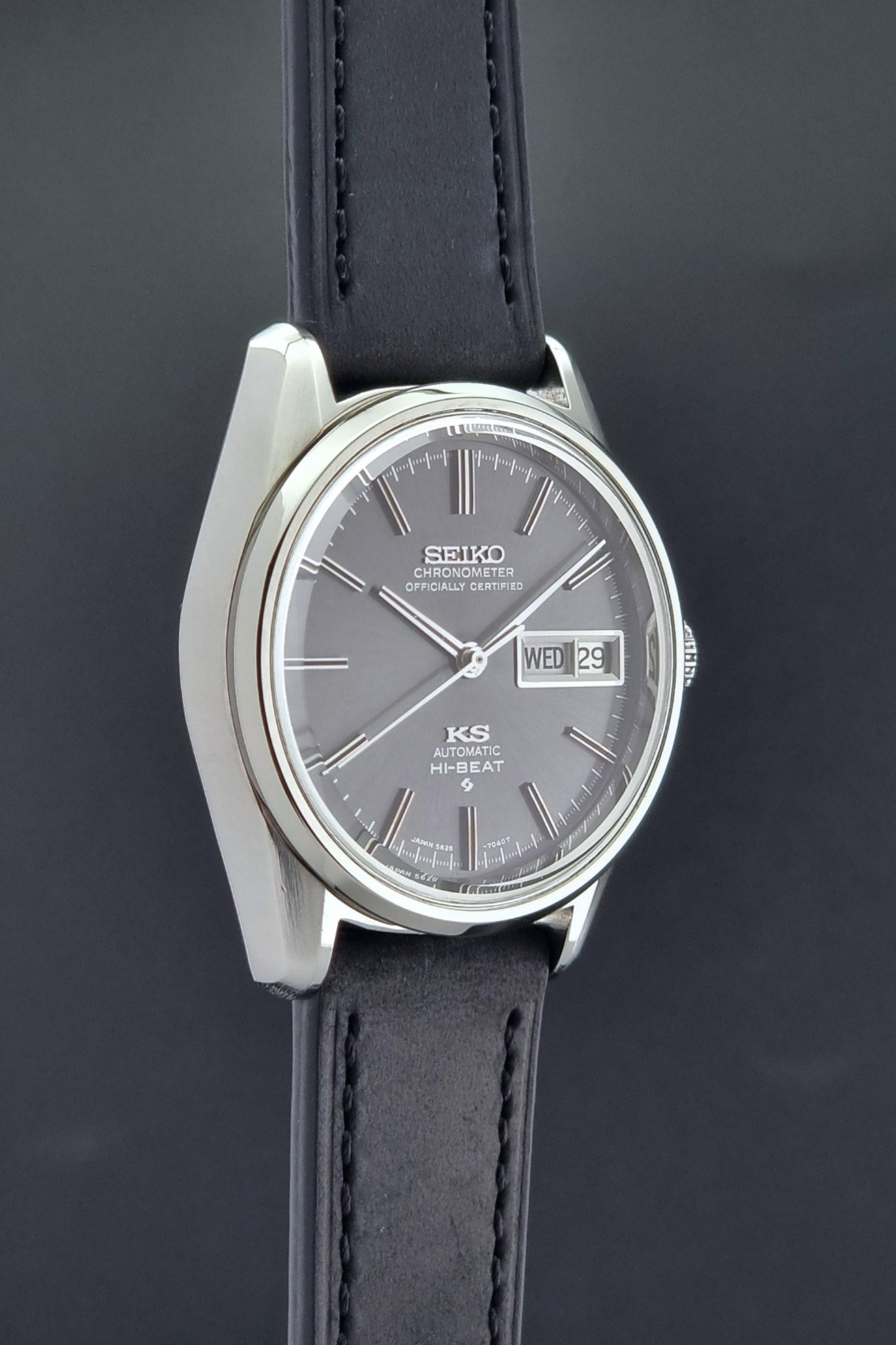 King Seiko watch 5626-7040 watch with black leather strap on a green and gray background side profile view