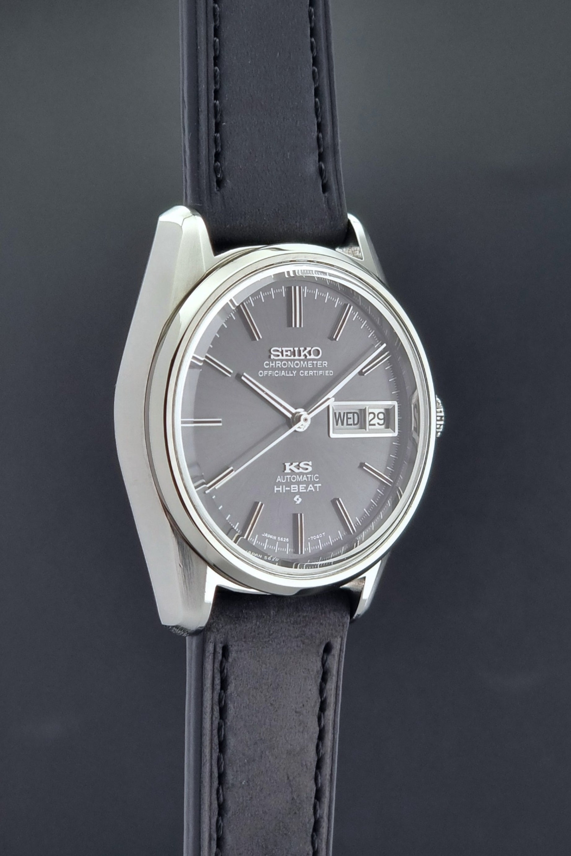 King Seiko watch 5626-7040 watch with black leather strap on a green and gray background side profile view