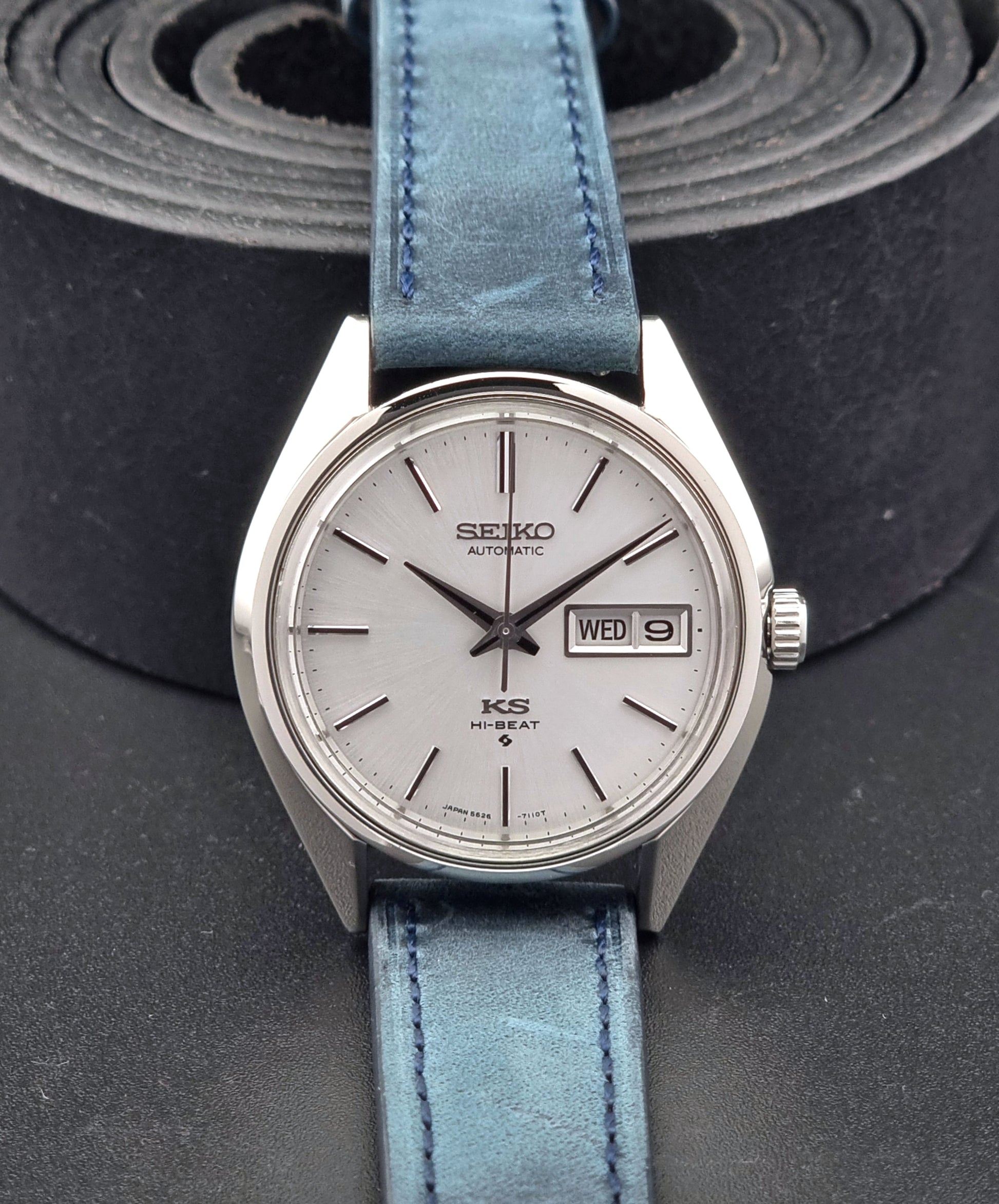 Vintage King Seiko 5626-7110 Wristwatch with blue strap and silver case on a dark textured background