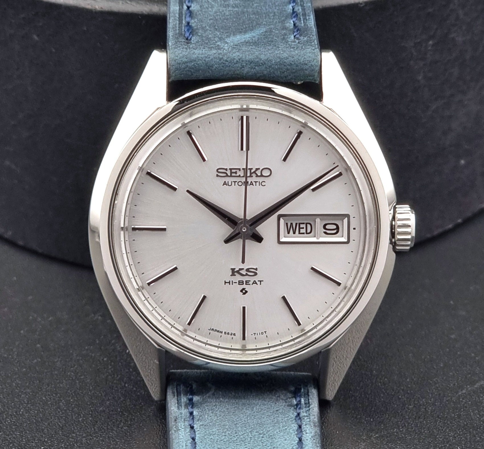 Vintage King Seiko 5626-7110 Wristwatch with blue strap and silver case on a dark textured background