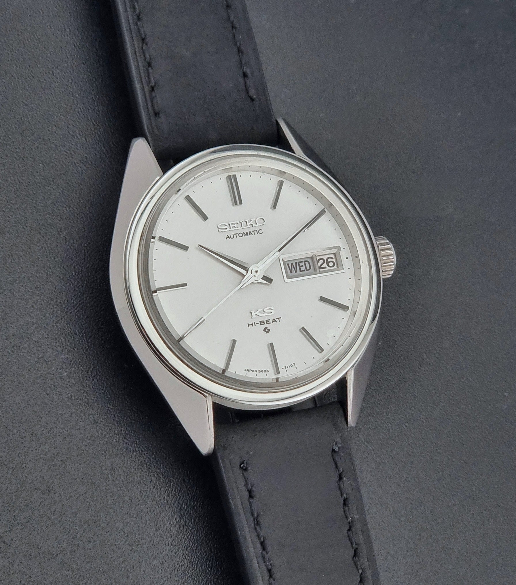Vintage King Seiko 5626-7110 wristwatch with black leather strap on a gray background front view