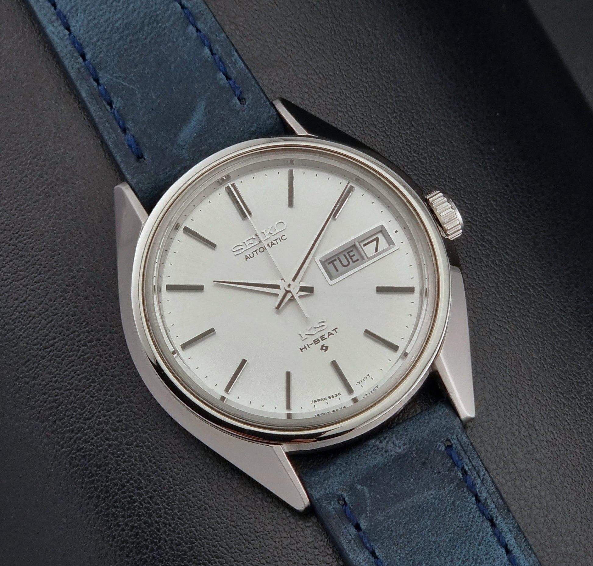Vintage King Seiko 5626-7110 Wristwatch with blue strap and silver case on a dark textured background