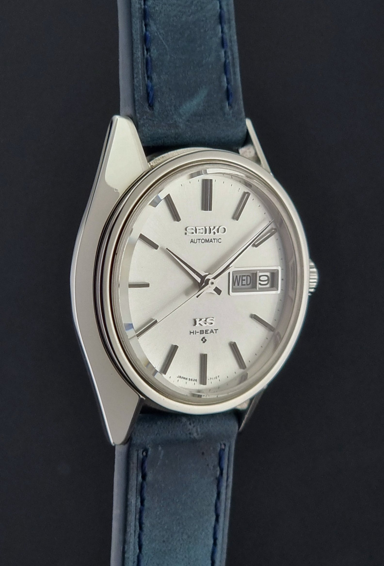 Vintage King Seiko 5626-7110 Wristwatch with blue strap and silver case on a dark textured background