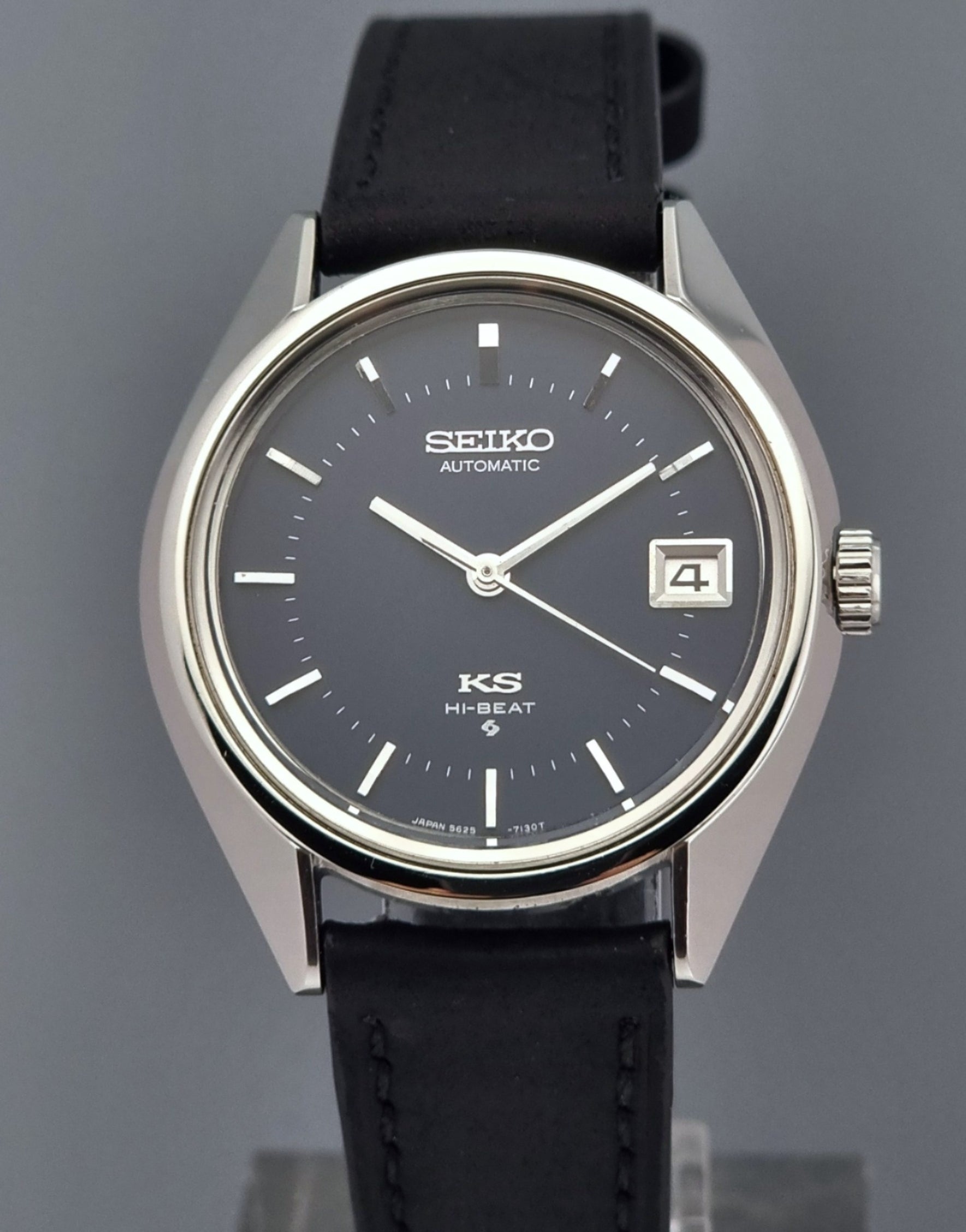 Vintage King Seiko watch with black leather strap on a gray background