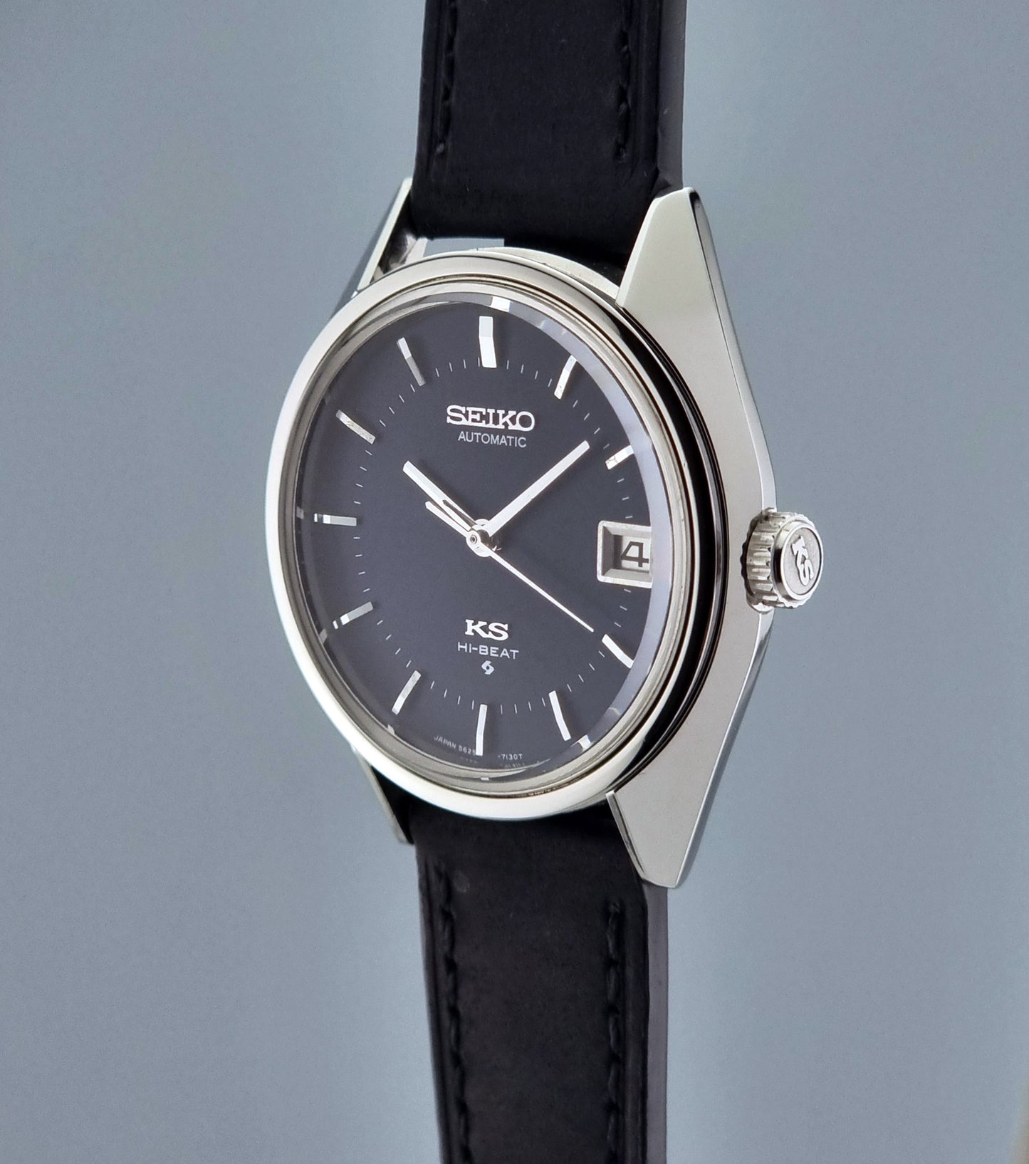 Vintage King Seiko watch with black strap and dark face on a gray background