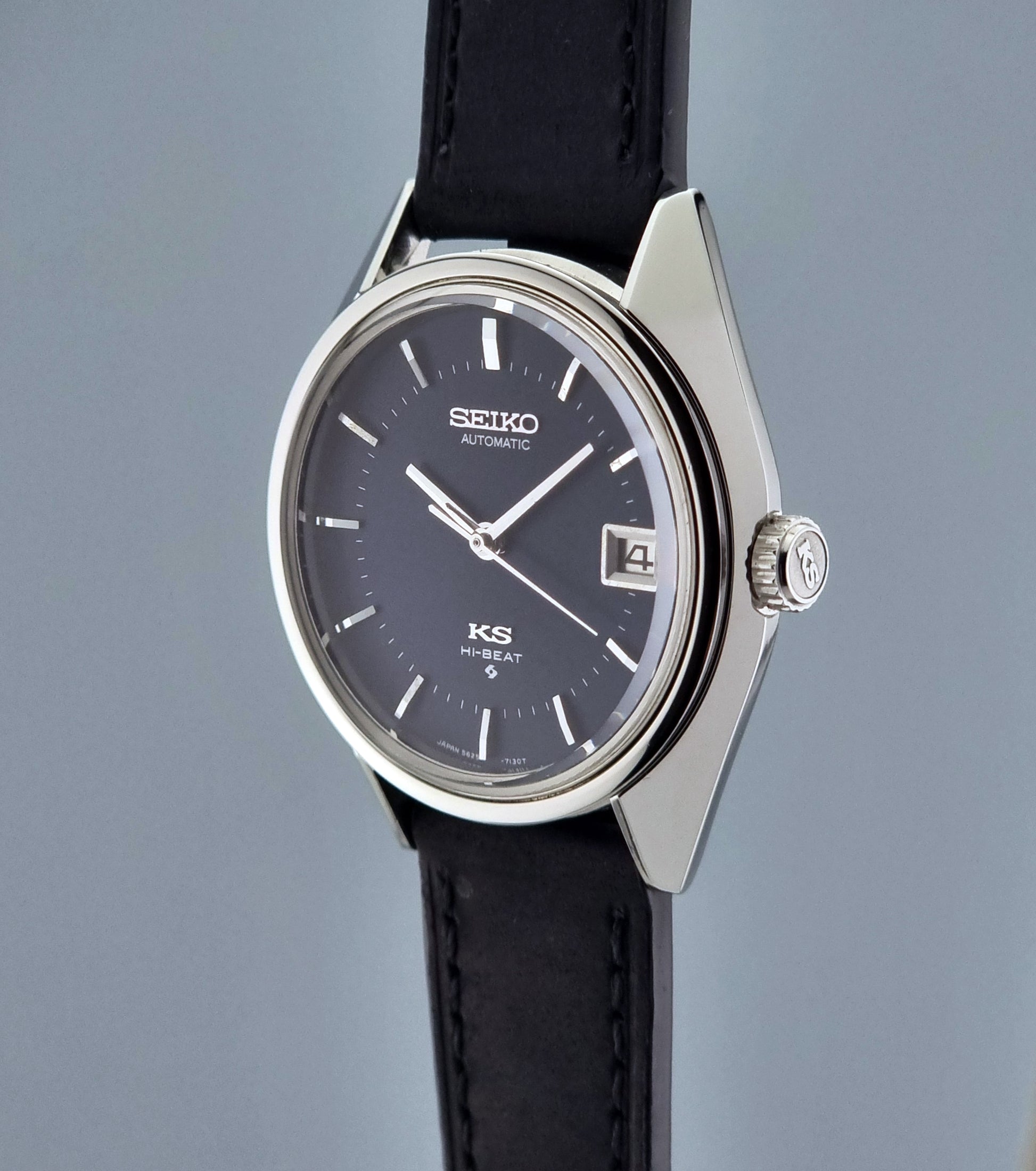 Vintage King Seiko watch with black strap and dark face on a gray background