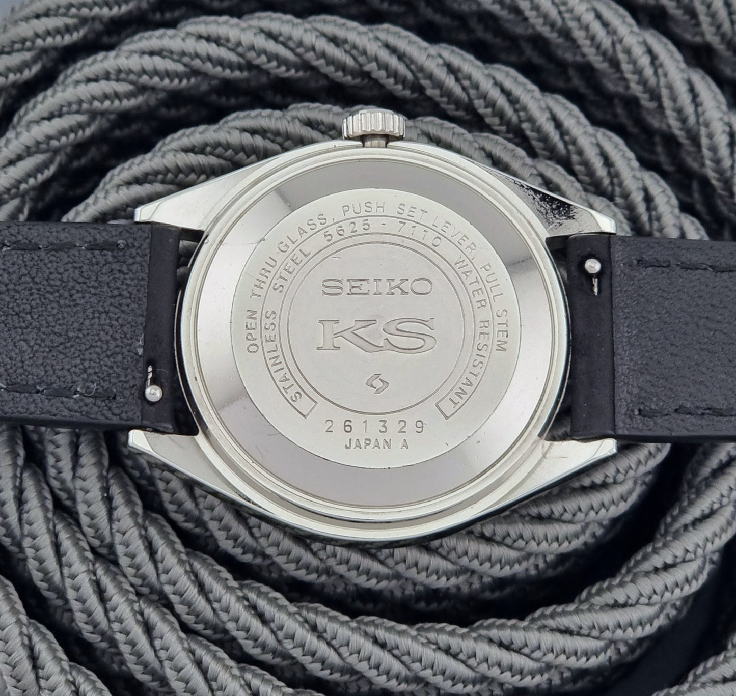 Seiko watch caseback on a textured gray background