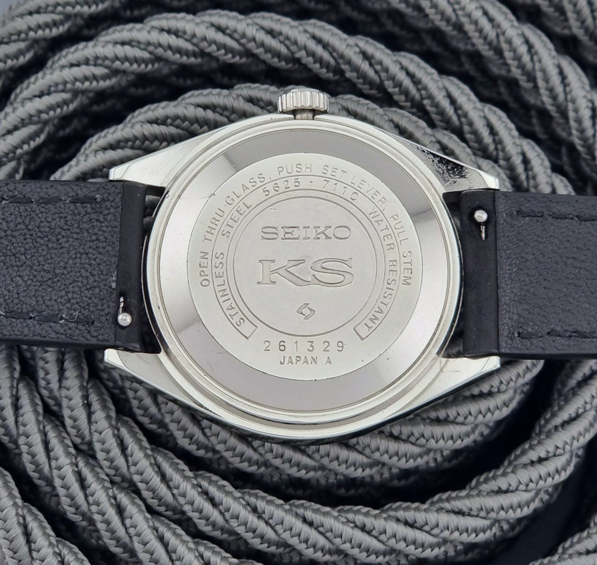 Seiko watch caseback on a textured gray background