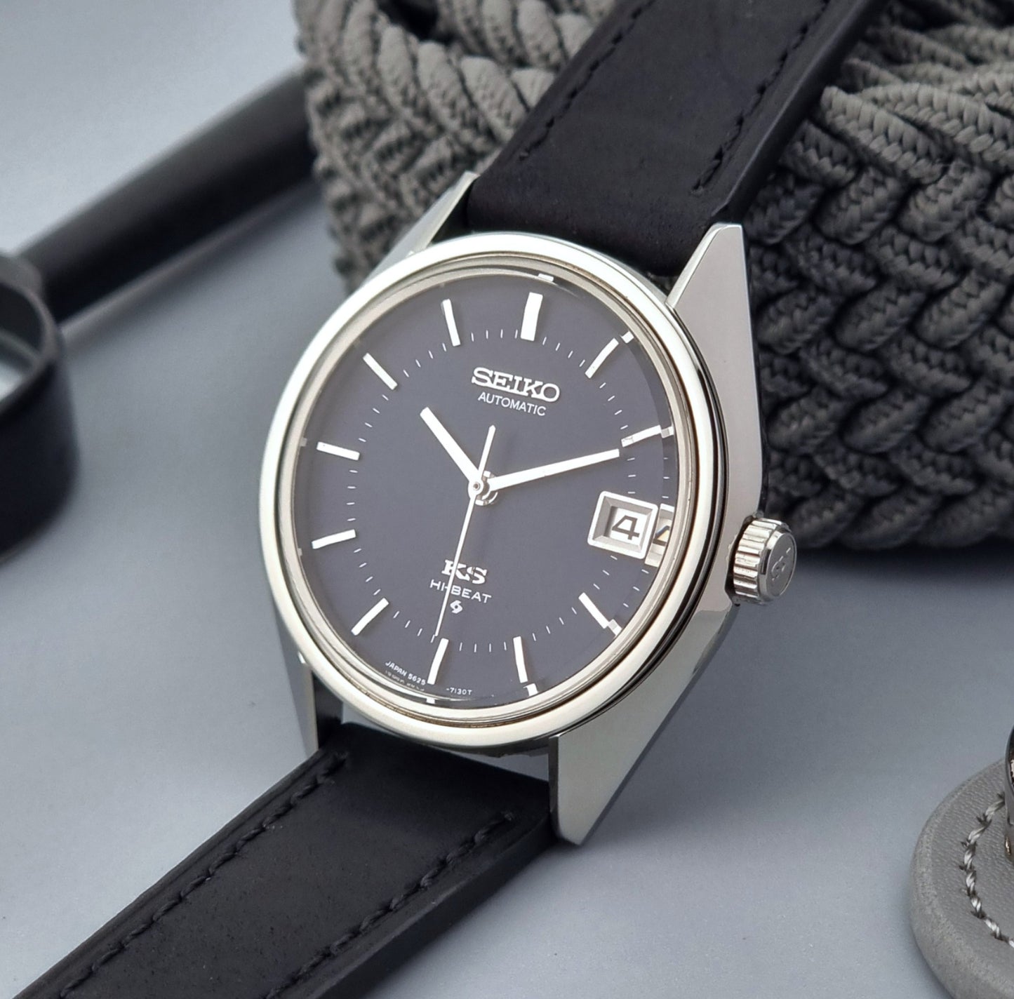 Vintage King Seiko watch with black strap on a gray surface