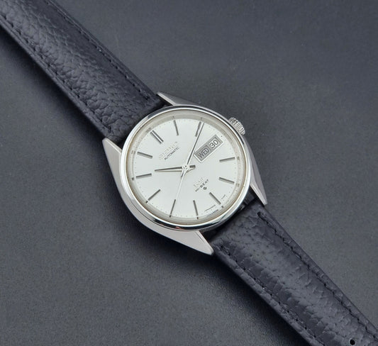 Vintage King Seiko 5626-7111 Wristwatch with a black strap on a dark background dial