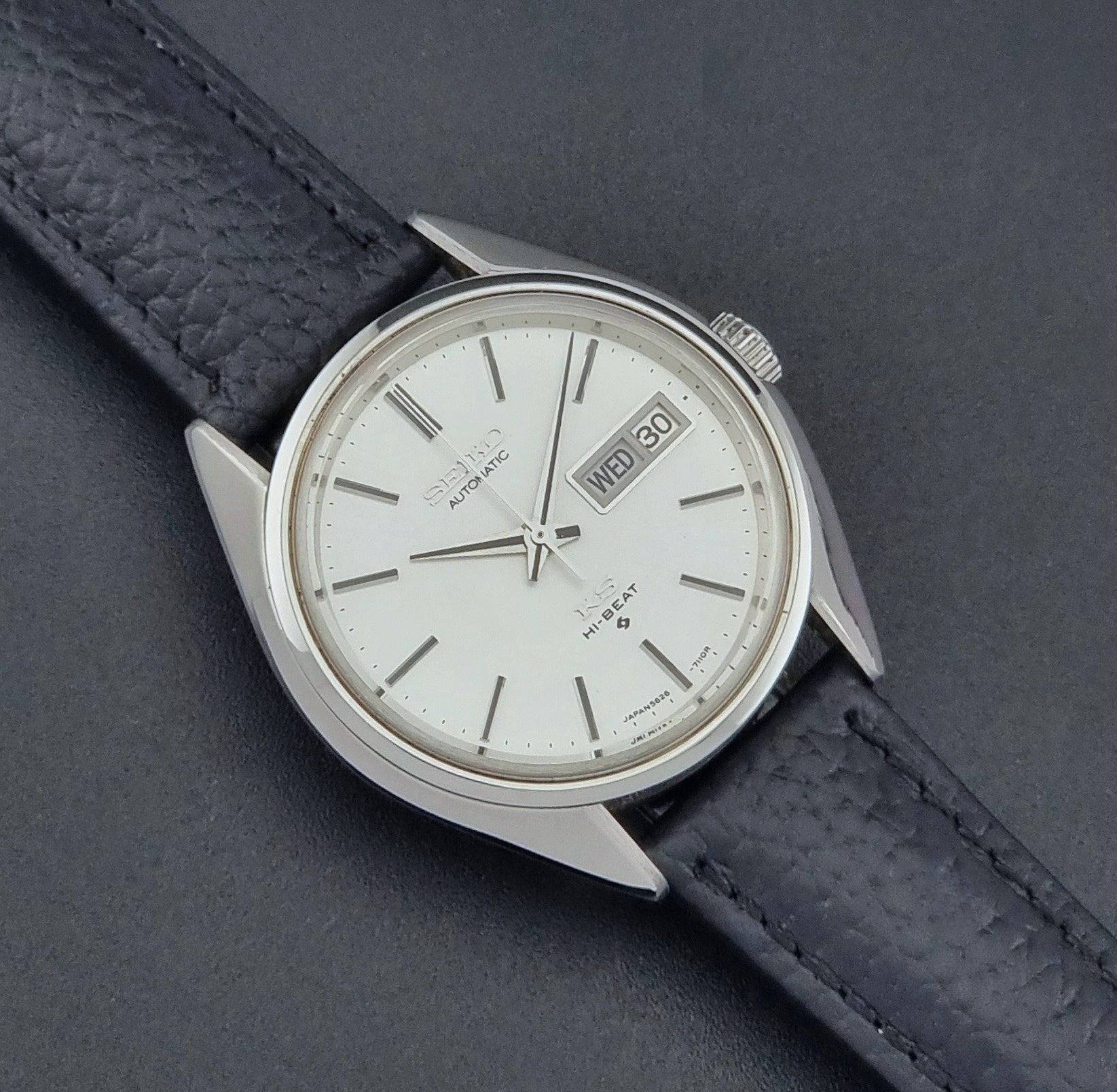 Vintage King Seiko 5626-7111 Wristwatch with a black strap on a dark background close up dial view