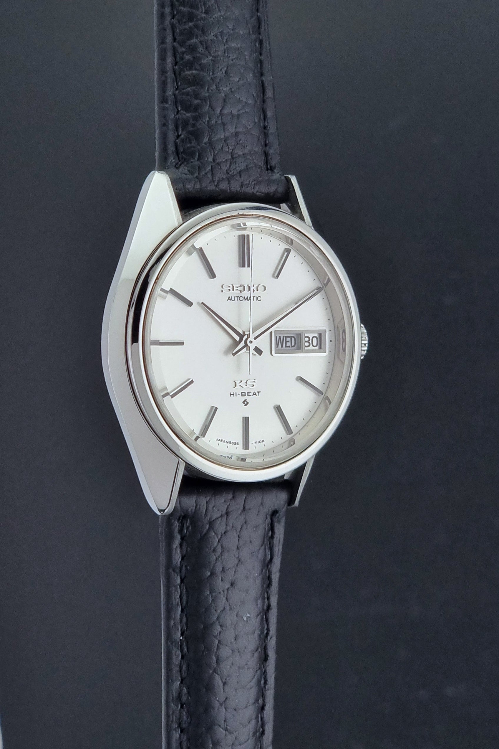Vintage King Seiko 5626-7111 Wristwatch with a black strap on a dark background side profile view