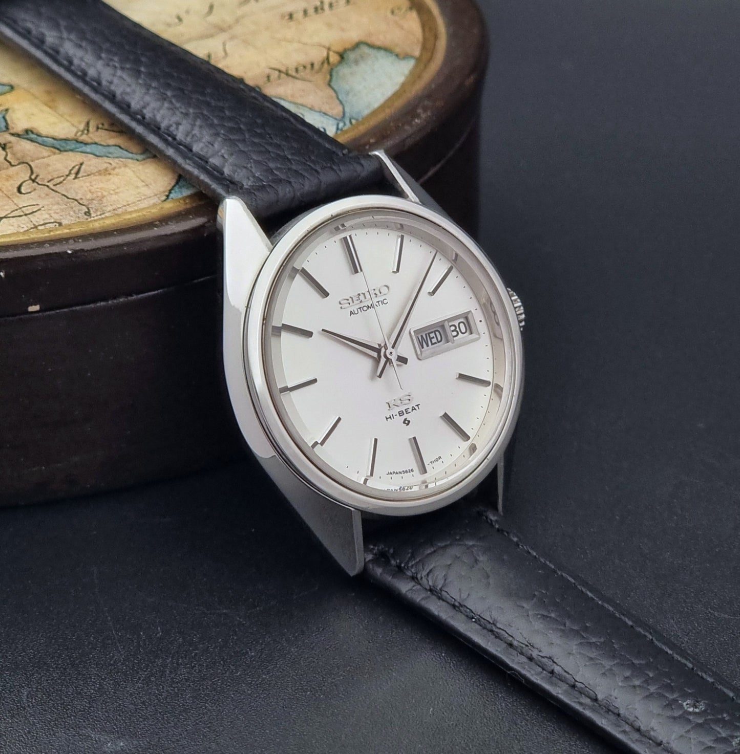 Vintage King Seiko 5626-7111 Wristwatch with a black strap on a dark background side view