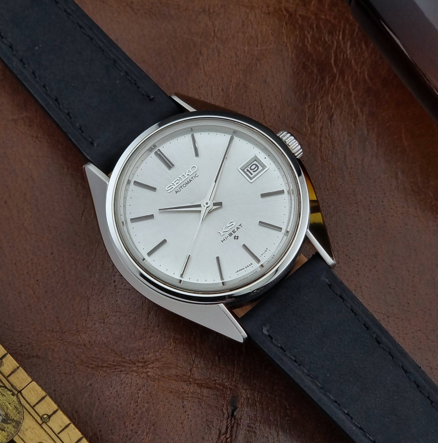 Vintage King Seiko watch with a white dial on a brown leather background 