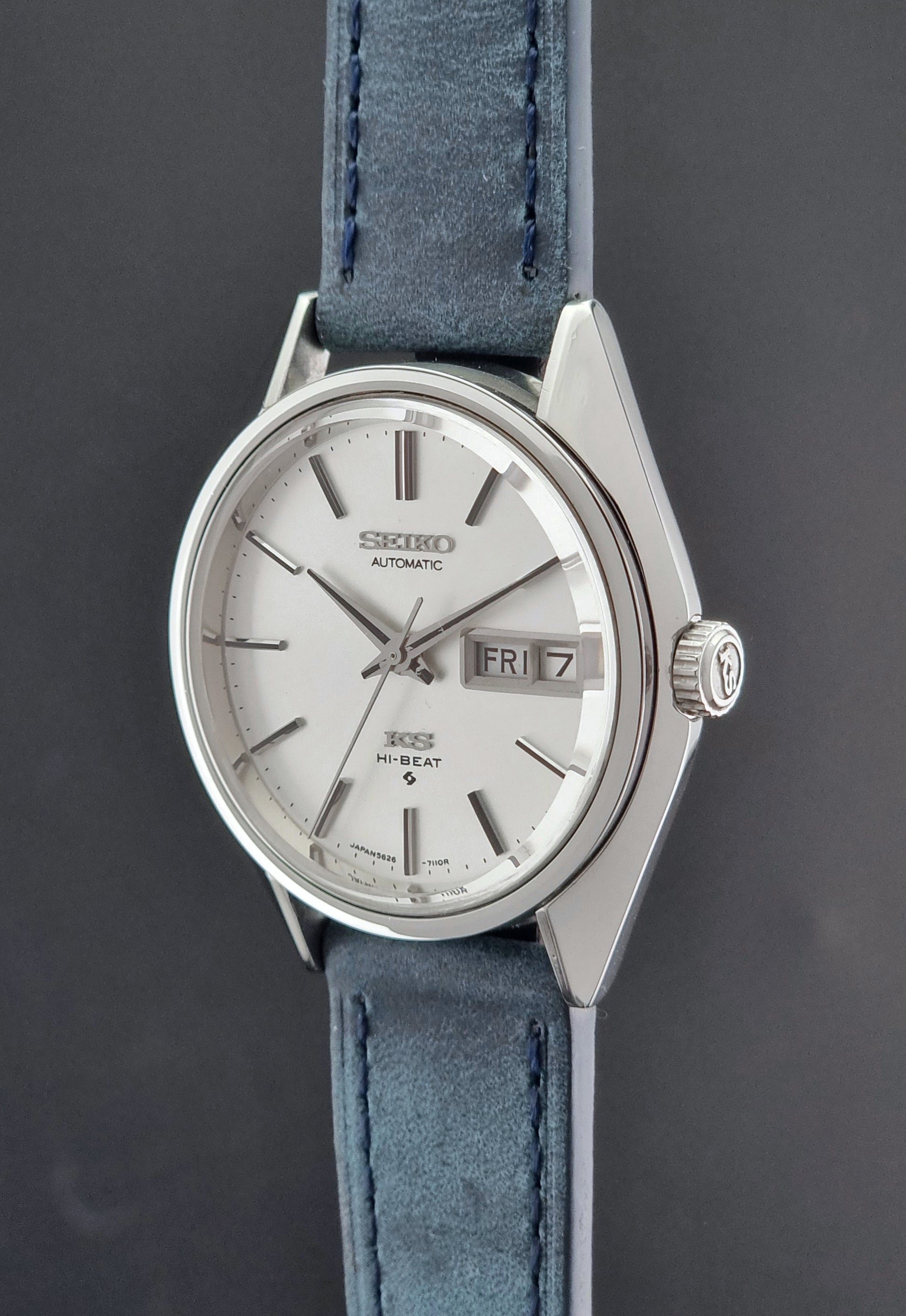 Vintage King Seiko wristwatch with a blue strap on a gray background crown profile