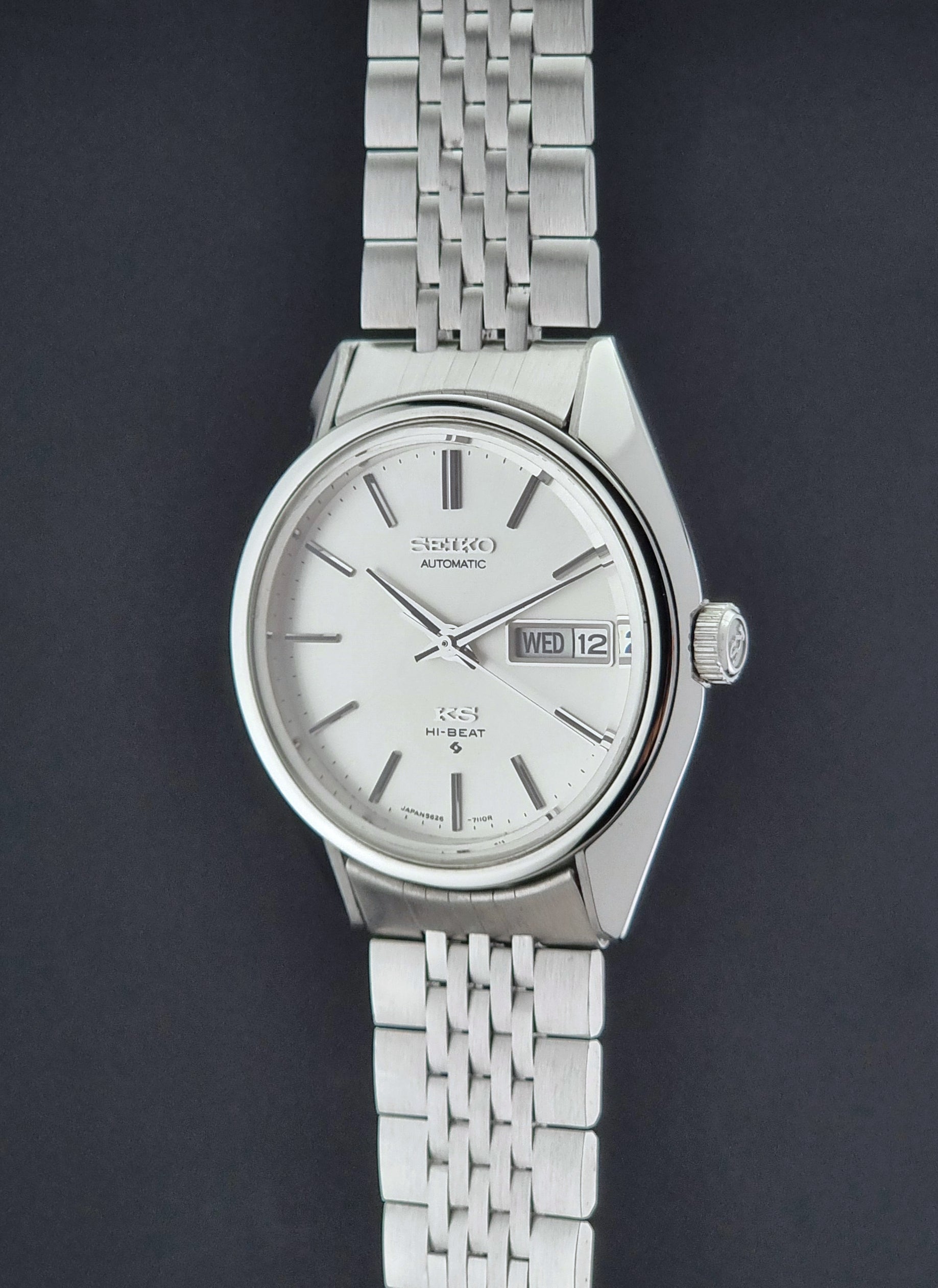 Vintage King Seiko Wristwatch 5626-7113 with a white face on a dark background crown profile view