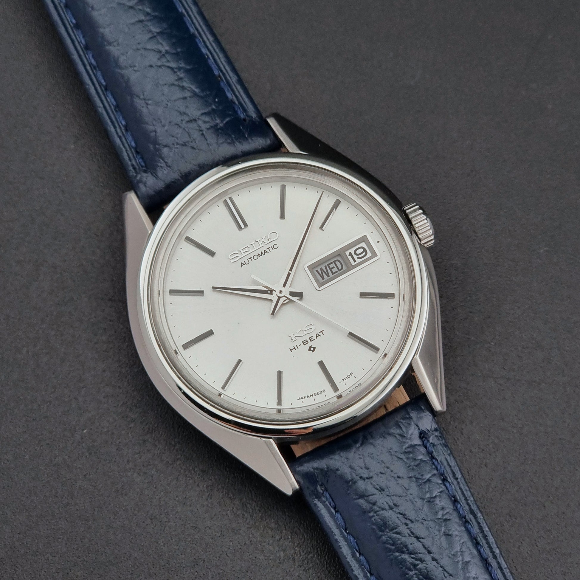 Vintage King Seiko 5626-71113 Wristwatch with blue leather strap and silver case on a dark gray background