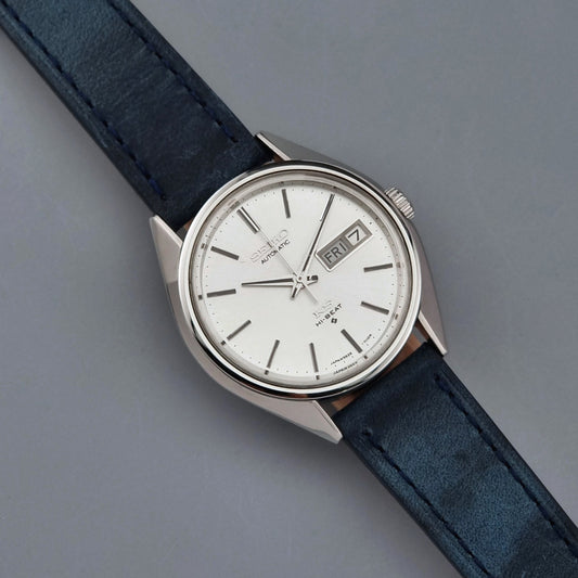 Vintage King Seiko wristwatch with a blue strap on a gray background dial view