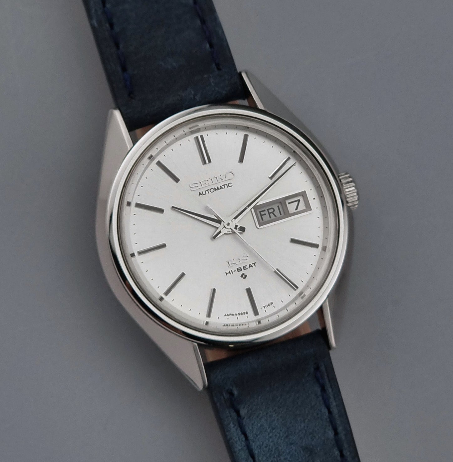 Vintage King Seiko wristwatch with a blue strap on a gray background close up dial view
