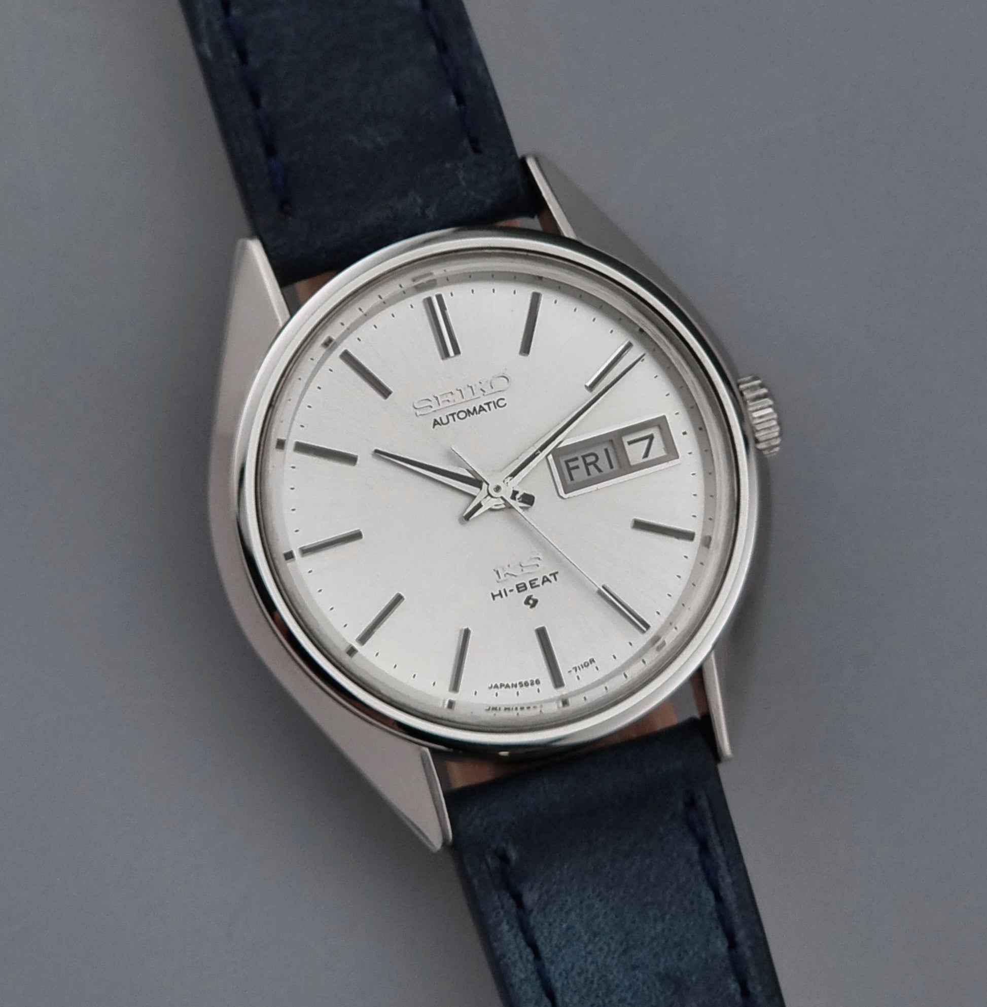 Vintage King Seiko wristwatch with a blue strap on a gray background close up dial view