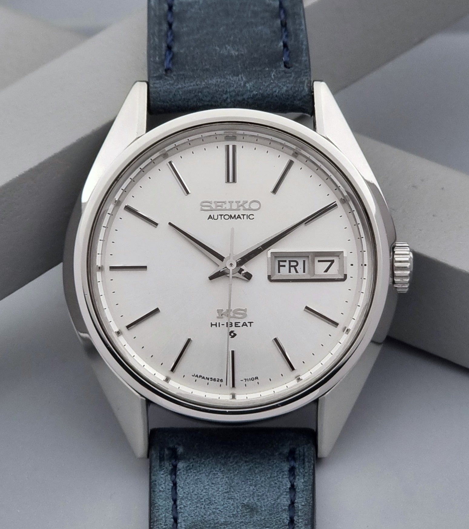 Vintage King Seiko wristwatch with a blue strap on a gray background close dial view