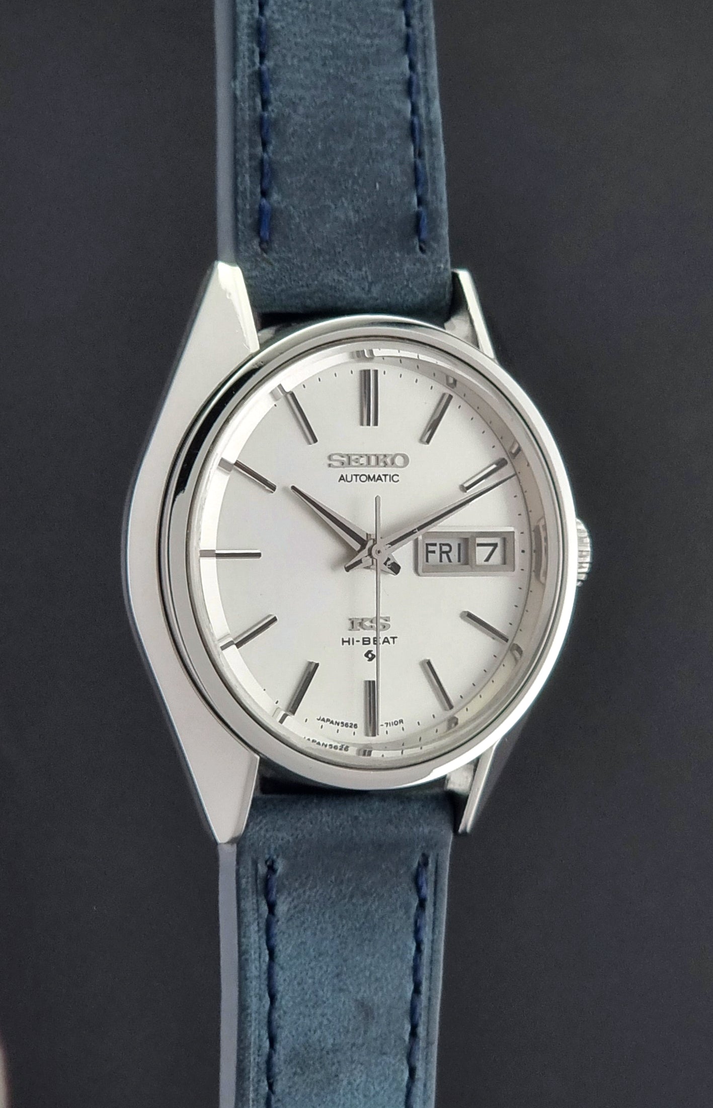 Vintage King Seiko wristwatch with a blue strap on a gray background side profile