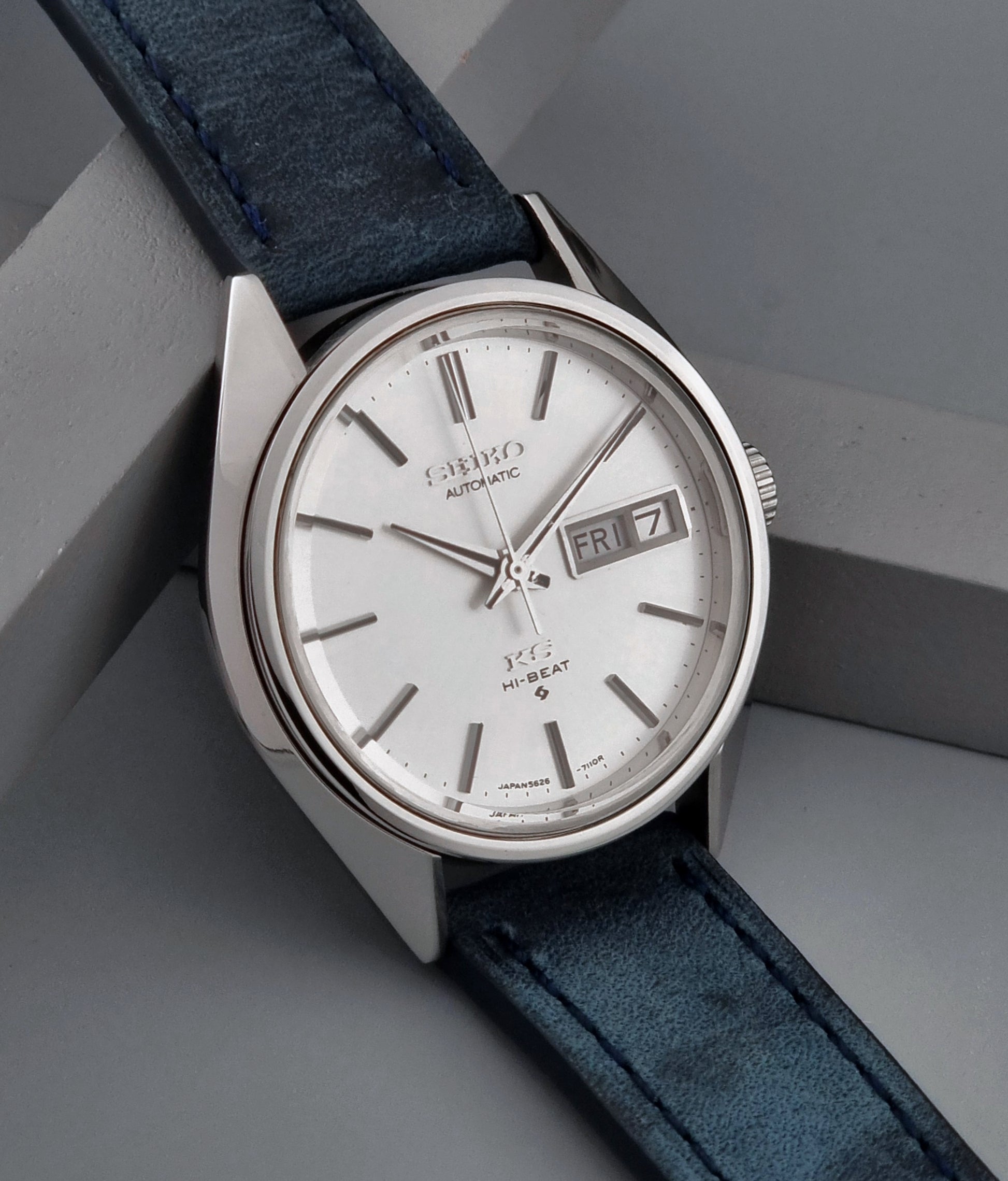 Vintage King Seiko wristwatch with a blue strap on a gray background side view