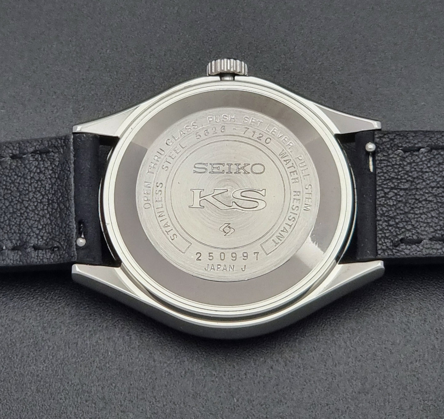 Vintage King Seiko Wristwatch Hi-beat 5626-7120 with a black strap on a dark background case back with KS logo